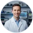 Technicien informatique souriant en blouse blanche devant des appareils de mesure électronique pour le diagnostic de matériel, à Genève.