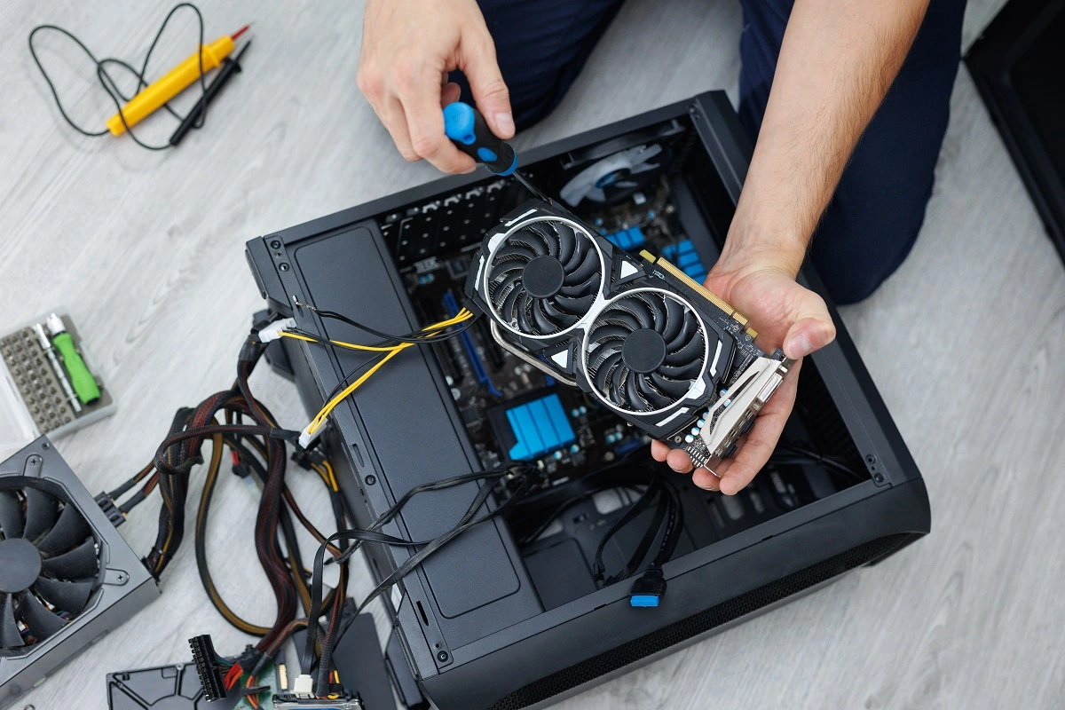 Technicien installant une carte graphique dans un boîtier PC gamer ouvert à Genève